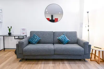 a living room with a couch and a mirror at Beau studio cozy centre ville et plages avec terrasse n3 in Nice