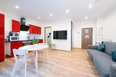 a kitchen and a living room with a table and a couch at Beau studio cozy centre ville et plages avec terrasse n3 in Nice