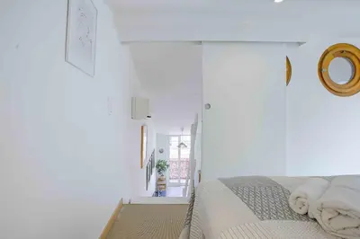a white bedroom with a bed and a mirror at Maison Bianchi - 27 Lepante in Nice