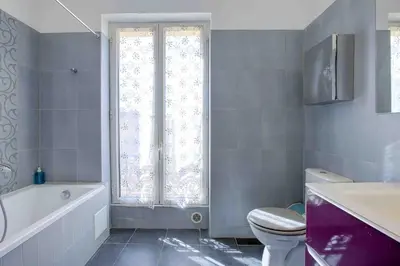 a bathroom with a toilet and a tub and a window at Maison Bianchi - 27 Lepante in Nice