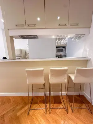 a kitchen with three bar stools in front of a counter at Les Terrasses D'Herold in Nice