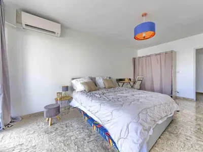 a white bedroom with a large bed in it at 1 min to beach bedroom flat with 2 AC and parking in summer in Nice