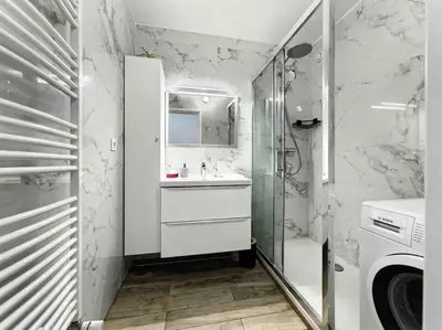a white bathroom with a sink and a shower at 1 min to beach bedroom flat with 2 AC and parking in summer in Nice