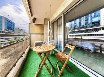 a table and chair on a balcony with a view at 1 min to beach bedroom flat with 2 AC and parking in summer in Nice