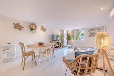 a living room with a table and chairs at Charmant 2 pièces au cœur de St Jean Cap Ferrat in Saint-Jean-Cap-Ferrat