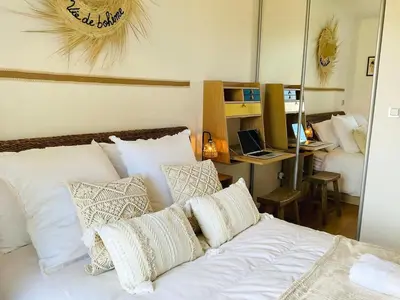 a bedroom with a bed and a desk with a laptop at Le Garib in Nice