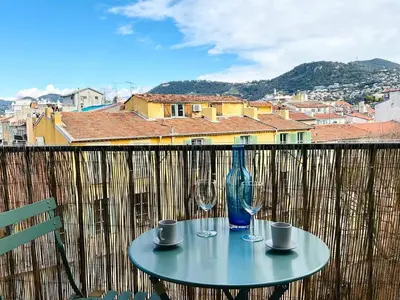 a table with two wine glasses on a balcony at Le Garib in Nice
