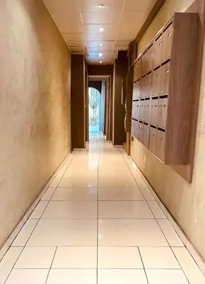 a hallway with white tile floors and lockers at Le Garib in Nice