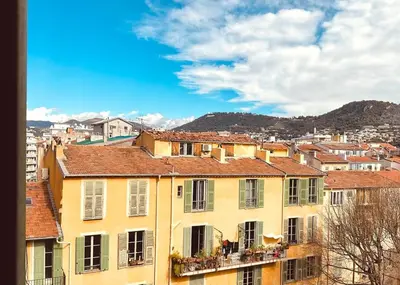 a yellow building with windows and balconies in a city at Le Garib in Nice
