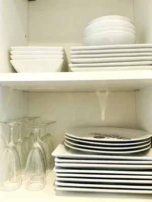 a white cabinet filled with plates and bowls and dishes at Le Garib in Nice