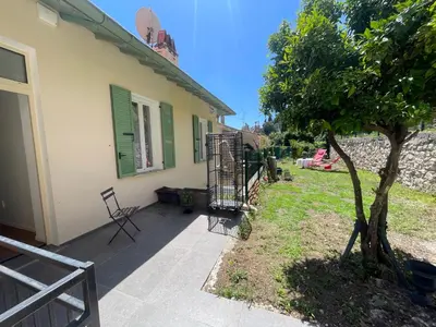 a patio with chairs and a tree next to a house at 5 mn du centre de Beaulieu. in Beaulieu-sur-Mer