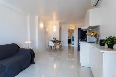 a kitchen and living room with a couch and a table at Cap Ferrat View III AP4401 By Riviera Holiday Hom in Saint-Jean-Cap-Ferrat