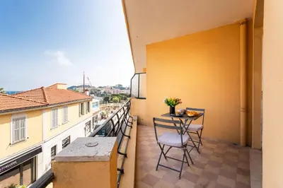 a balcony with a table and chairs on a building at Cap Ferrat View III AP4401 By Riviera Holiday Hom in Saint-Jean-Cap-Ferrat