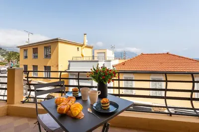 a table with bread and pastries on a balcony at Cap Ferrat View III AP4401 By Riviera Holiday Hom in Saint-Jean-Cap-Ferrat