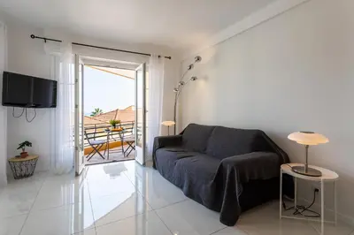 a living room with a couch and a balcony at Cap Ferrat View III AP4401 By Riviera Holiday Hom in Saint-Jean-Cap-Ferrat