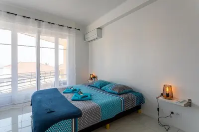 a bedroom with a bed with blue pillows and a window at Cap Ferrat View III AP4401 By Riviera Holiday Hom in Saint-Jean-Cap-Ferrat