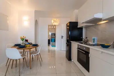a kitchen with a table and a dining room at Cap Ferrat View III AP4401 By Riviera Holiday Hom in Saint-Jean-Cap-Ferrat
