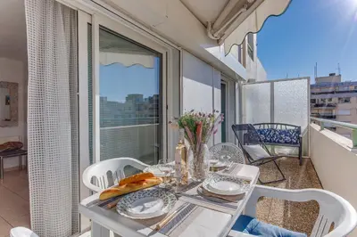 a dining table and chairs on a balcony with a view at PALAIS DES ARTS AP4399 By Riviera holiday homes in Nice