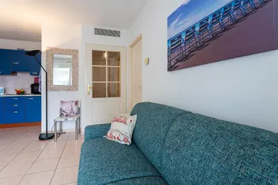 a living room with a blue couch and a kitchen at PALAIS DES ARTS AP4399 By Riviera holiday homes in Nice