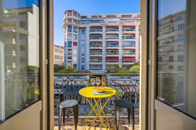 a balcony with a yellow table and two chairs at Maison Bianchi - Hôtel des Postes in Nice