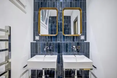 a bathroom with two sinks and two mirrors at Maison Bianchi - Hôtel des Postes in Nice