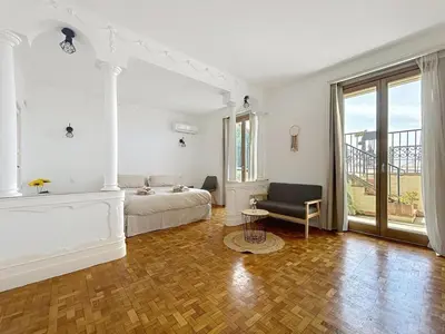 a large white bedroom with a bed and a chair at Villa kriss in Nice