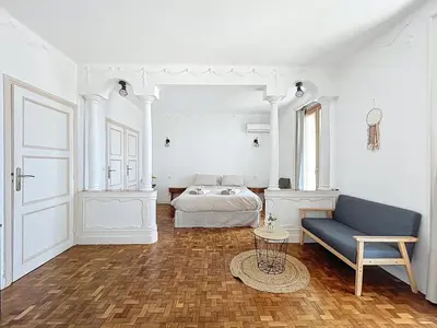 a white room with a bed and a blue couch at Villa kriss in Nice