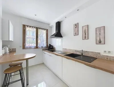 a kitchen with white cabinets and a sink and a counter at Villa kriss in Nice