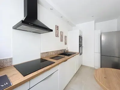 a white kitchen with a stove and a refrigerator at Villa kriss in Nice