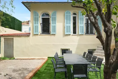 a table and chairs in front of a house at VILLA DES PERGOLAS -6 Bdrs - 5 bathrs -Parking -Jardin -JACUZZI -TRAMstation , 10 min beach in Nice