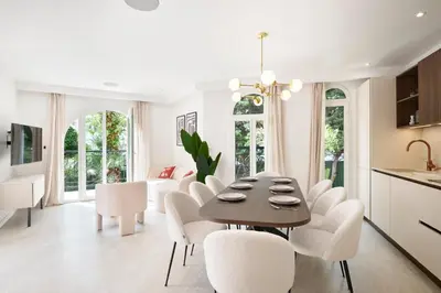 a kitchen and dining room with a table and white chairs at VILLA DES PERGOLAS -6 Bdrs - 5 bathrs -Parking -Jardin -JACUZZI -TRAMstation , 10 min beach in Nice