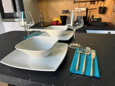 a table with two white plates and wine glasses at Paradise Studio - Hyper Centre in Nice