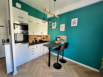 a kitchen with a table and a green wall at Paradise Studio - Hyper Centre in Nice