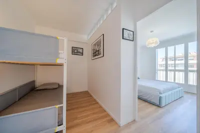 a room with a bunk bed and a bedroom with a window at Appartement à 100m de la plage, climatisé in Cagnes-sur-Mer