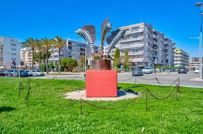 a statue in the middle of a field with a street at Appartement à 100m de la plage, climatisé in Cagnes-sur-Mer