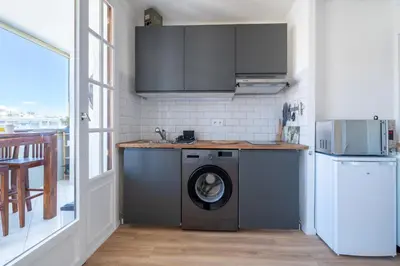 a kitchen with a washing machine in a room at Appartement à 100m de la plage, climatisé in Cagnes-sur-Mer
