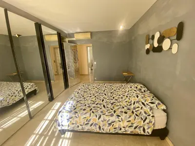 a bedroom with a bed and a mirror at Grand F3- Centre ville de Nice, Wifi AC in Nice