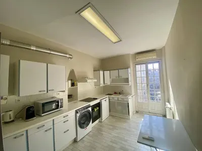 a kitchen with white cabinets and a washer and dryer at Grand F3- Centre ville de Nice, Wifi AC in Nice