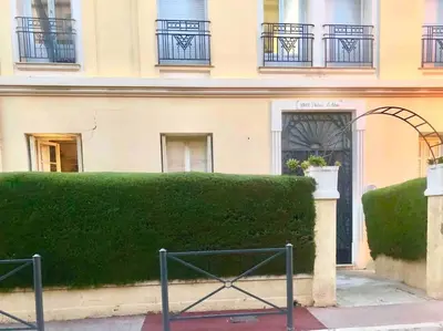 a green hedge in front of a building at Charming apartment in Beaulieu sur Mer in Beaulieu-sur-Mer