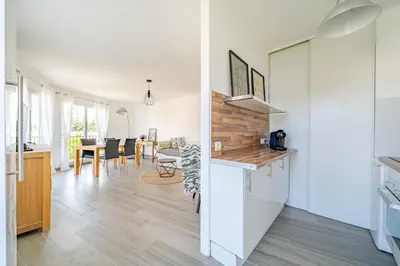 a kitchen and living room with white walls and wooden floors at Confortable 2 pièces 54 m2 proche de la mer in Nice