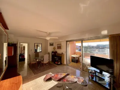 a living room with a tv and a table at 2P Cagnes Sur Mer- Proximité Plage, Parking in Cagnes-sur-Mer