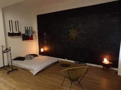 a bedroom with a chalkboard wall with a bed and chairs at Studio japonisant in Nice