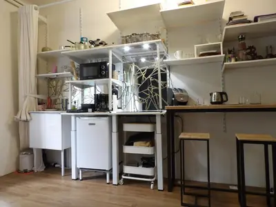 a kitchen with white shelves and a counter at Studio japonisant in Nice
