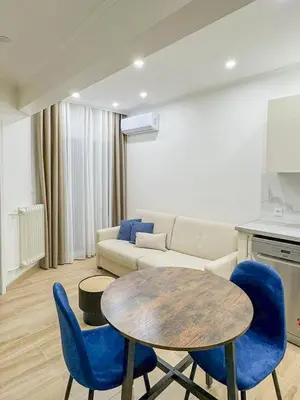a living room with a table and blue chairs at Gare Du Sud - Wifi, AC, balcon in Nice