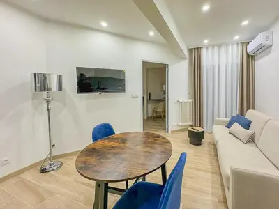 a living room with a table and a couch at Gare Du Sud - Wifi, AC, balcon in Nice