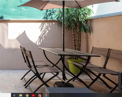a table and chairs with an umbrella and a plant at LOFT à deux pas de la Mer avec terrasse n2 in Nice