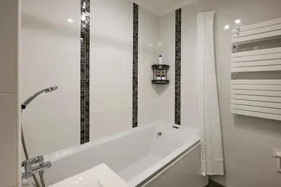 a white bathroom with a tub and a shower at Moderne 2/3 Pièces près du Port in Nice
