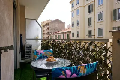 a table with a plate of food on a balcony at Moderne 2/3 Pièces près du Port in Nice
