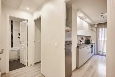 a kitchen with white walls and wooden floors at Moderne 2/3 Pièces près du Port in Nice