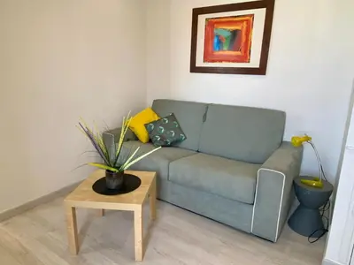 a living room with a blue couch and a table at STUDIO VERT FSHH in Nice